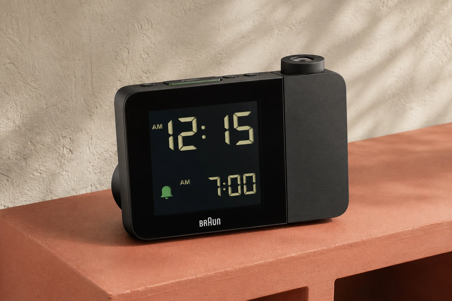 Black Braun BC15BUS projection alarm clock on a terracotta bedside shelf — editorial illustration